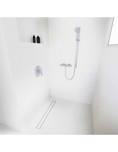 Open walk-in shower, surrounded by light-colored microcement floor and walls, with fittings in Silver - tiled cover side