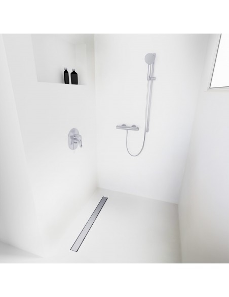 Open walk-in shower, surrounded by light-colored microcement floor and walls, with fittings in Silver - solid cover side