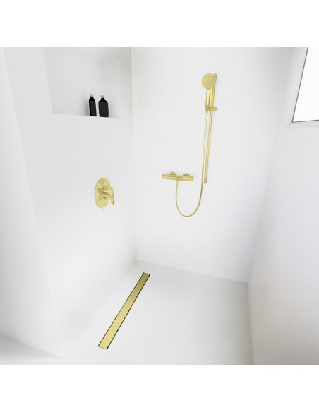 Open walk-in shower, surrounded by light-colored microcement floor and walls, with fittings in Gold