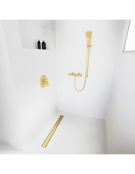 Open walk-in shower, surrounded by light-colored microcement floor and walls, with fittings in Brass - solid cover side