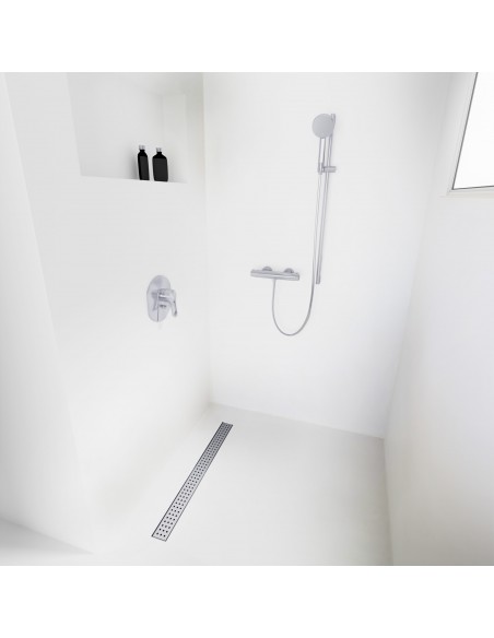 Open walk-in shower, surrounded by light-colored microcement floor and walls, with fittings in Silver