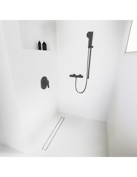 Open walk-in shower, surrounded by light-colored microcement floor and walls, with fittings in Black - tiled cover side