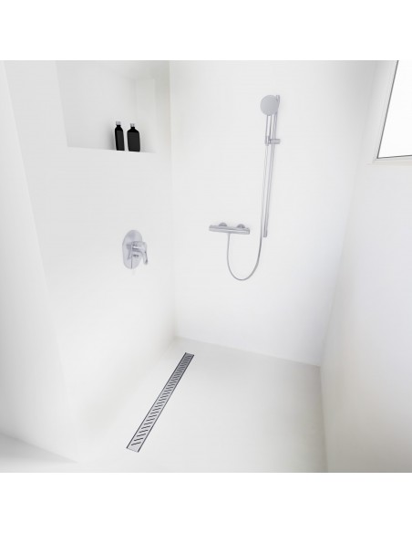 Open walk-in shower, surrounded by light-colored microcement floor and walls, with fittings in Silver