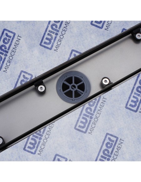 Stainless steel drain body without cover, revealing a centered outlet and adjustable frame for different tile thicknesses