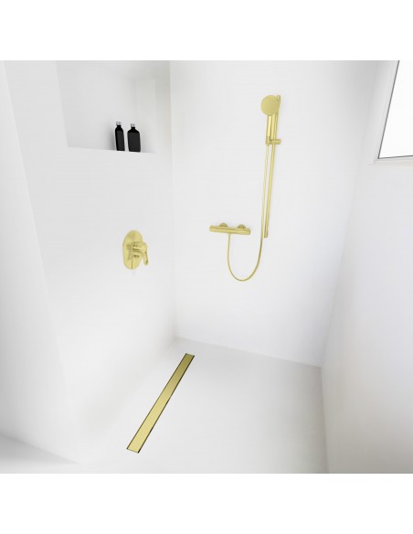 Open walk-in shower, surrounded by light-colored microcement floor and walls, with fittings in Gold - solid cover side
