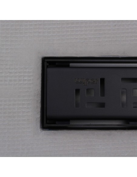 Close up on integrated Black linear drain with matching Tivano cover