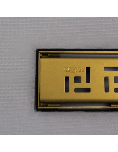 Close up on integrated Brass linear drain with matching Tivano cover