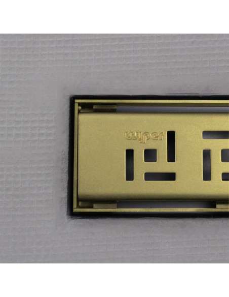 Close up on integrated Gold linear drain with matching Tivano cover