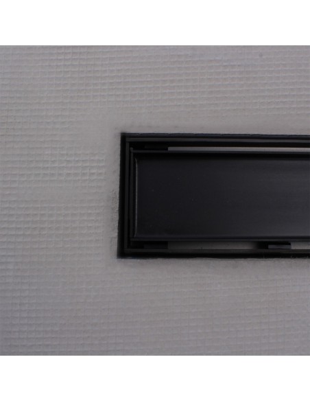 Close up on integrated Black linear drain with matching Reversible cover