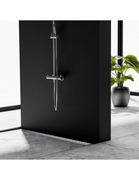 Example of open shower area on a cement-grey floor in marble-look with installed wall drain and with silver fittings