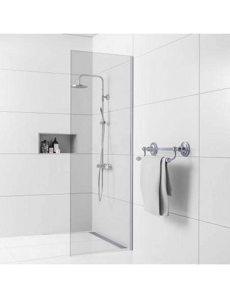 Example of traditional shower area with wall drain, finished with large white tiles and chrome-plated shower fittings